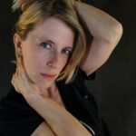 Elegant portrait of a woman posing indoors with a dramatic expression.